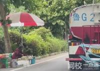 灑水車精準(zhǔn)避開(kāi)擺攤老人 擺攤老人淡定自若早已習(xí)以為常
